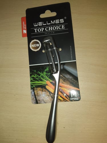 Customer's Wellmes New Peeler shown in its original black packaging on a wooden surface.