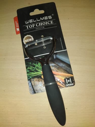 Customer's Wellmes Peeler with a black handle, shown in its original cardboard packaging on a table.