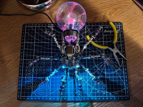 Customer's assembled Cyberpunk Plasma Ball Spider, lit up with a pink plasma ball and blue body lights.