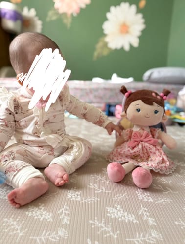 Customer's baby sitting on a playmat next to the soft Personalized Cherry Girl doll.