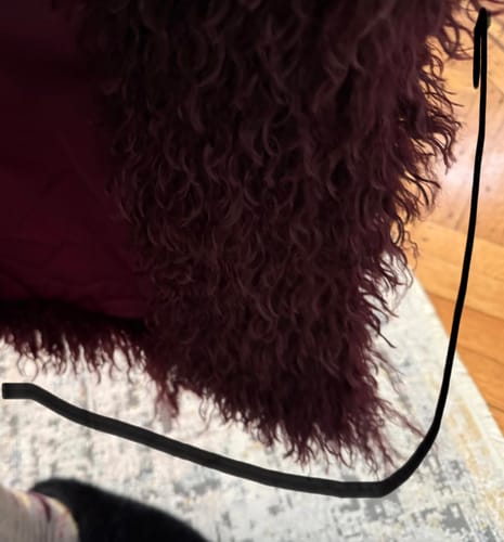 Partial view of the reviewer's Faux Fur Plush Long Coat showing the hem and lining.