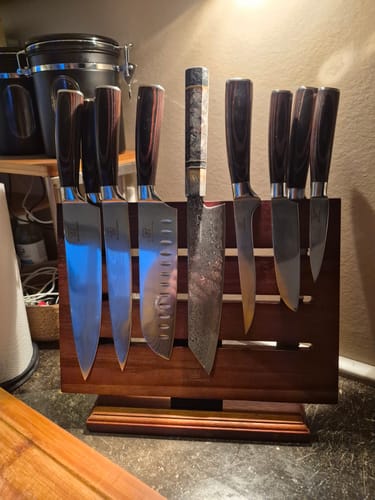 Eine Kundin zeigt das asiatische Jishaku-Messerset auf dem magnetischen Holzblock in ihrer Küche.