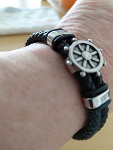 Customer wearing the Captain bracelet, showing the black braided band and silver ship's wheel clasp on their wrist.