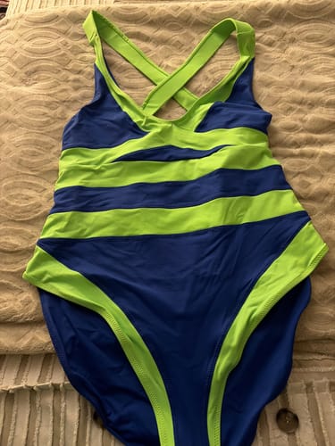 Customer's VENUS one-piece swimsuit in royal blue and lime, laid flat to show the striped pattern and criss-cross back.