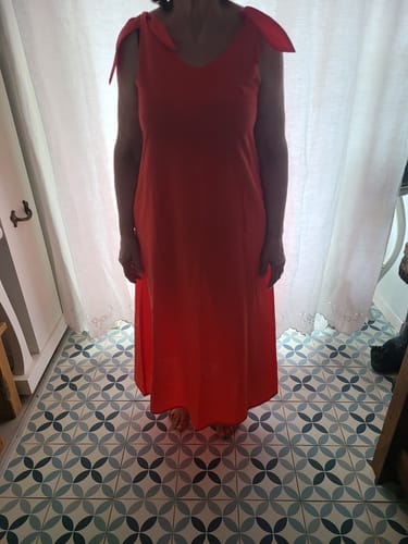 Une cliente portant la robe longue Laëtitia couleur feu, avec ses bretelles à nouer.