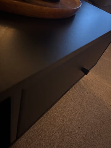 Recensent toont een close-up van de Salontafel Barlo, die het verschil in afwerking tussen het blad en de lade laat zien.