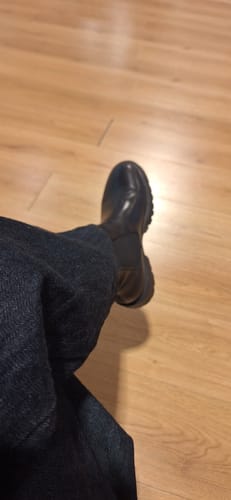 תצוגה חלקית של לקוחה הנועלת את מגפי Kenova השחורים שלה.