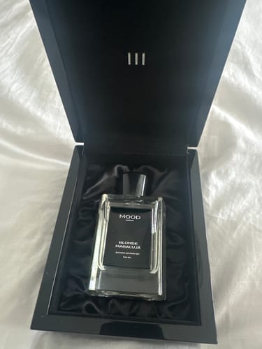 Customer's Blonde Maracujá perfume bottle presented in its open, elegant black box.