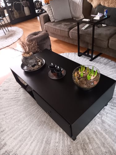 Recensent toont de gemonteerde, matzwarte Salontafel Barlo in een woonkamer.