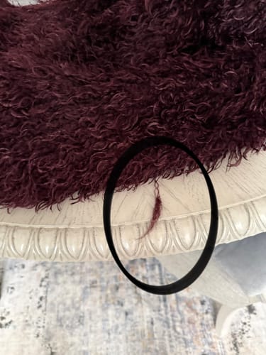 Close-up of reviewer's Faux Fur Plush Long Coat with a circled piece of shed fur.