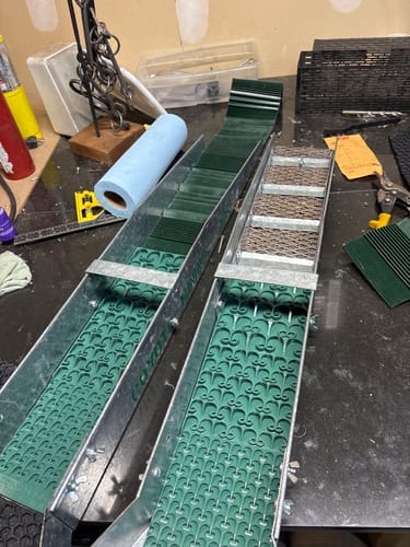 Customer's two green Combo Dream Mats installed in metal sluice boxes on a workbench.