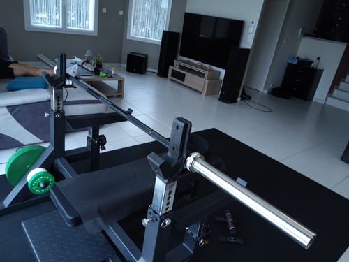 Customer's black chrome Calibrated Bastard Power Bar on a weight bench in a home gym setup.