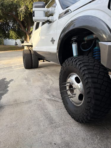 Customer's bottle of H2NO Ceramic Waterless Wash resting in the wheel well of a clean white truck.