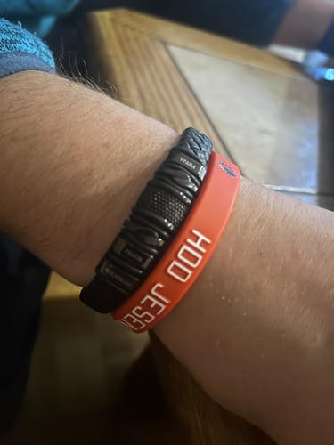 Reviewer showing the black personalized bracelet on their wrist alongside another band.