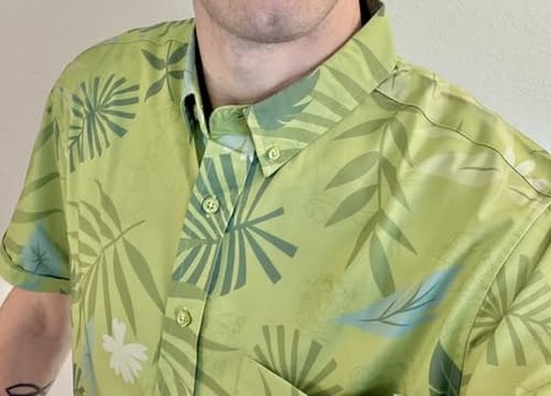 Close-up of a reviewer wearing the light green Zootopia 'The Wilde Side' shirt, showing the tropical leaf pattern.