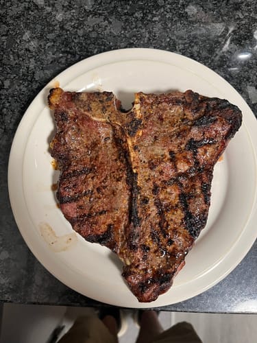 Reviewer's large, grilled Porterhouse steak from the Beef & Steak Grilling Bundle served on a white plate.