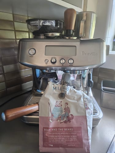 A customer's 1kg bag of Bear and the Beard coffee placed in front of their silver home espresso machine.