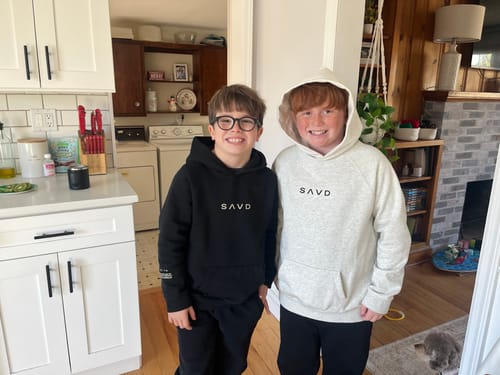 Customer's review photo of two youths wearing the Youth Oversized Hoodie in black and light grey.