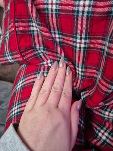 Reviewer's hand showing the long, shimmery Snow Globe press-on nails included in the gift set.