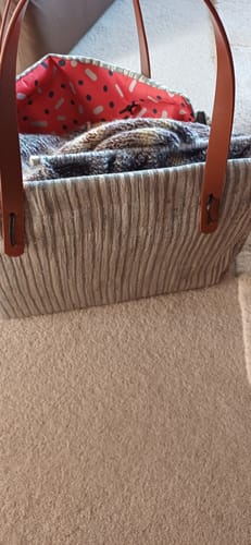 Customer's striped Deluxe Knitting Bag showing the reversible red patterned interior holding a knitting project.