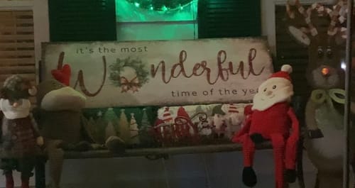 Customer's 'It's the most Wonderful Time of the Year' sign on a bench with festive Christmas figures.