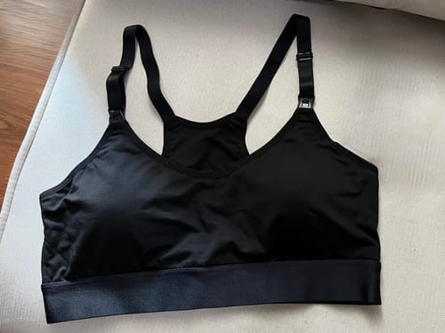 Customer's black Skye Pump Bra laid flat on a couch, showing the adjustable straps and clips.