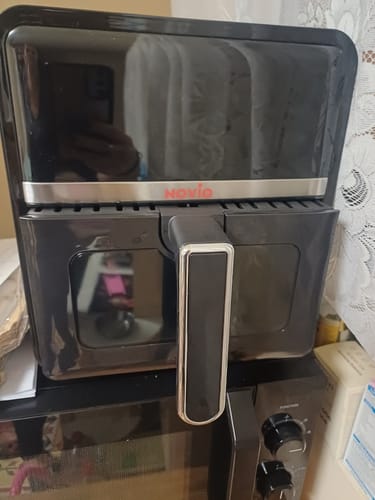 Clientul arată friteuza sa neagră Novio StonePro, așezată pe un cuptor cu microunde.