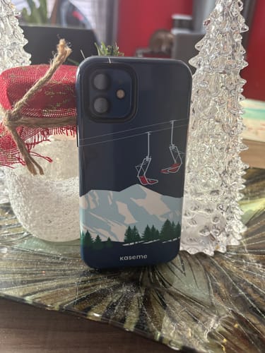A customer's blue Ski Lift phone case standing on a table, showing the mountain and ski lift design.
