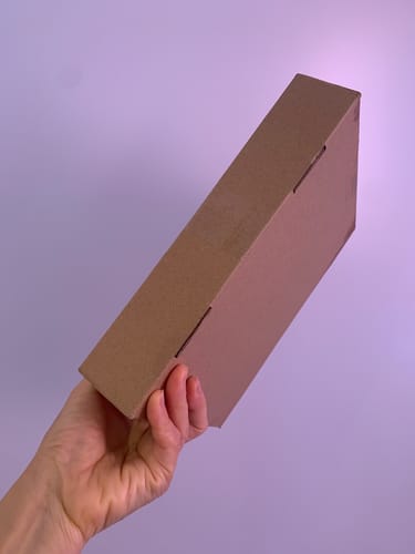 購入者が手に持つ、GIP/GLP-1医療注射ダイエットが入ったコンパクトな段ボール箱。