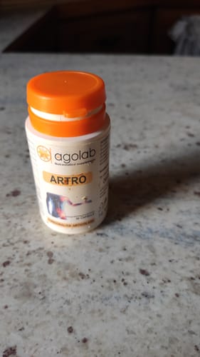 Un cliente mostra il flacone bianco del prodotto Artro con il suo tappo arancione.