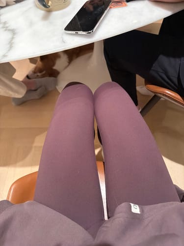 Customer's first-person view while seated, wearing the brown V Leggings and showing the smooth fit on their thighs.