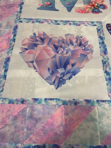 Customer's Watercolor Crystalized Heart Fabric Panel with vibrant colors sewn into a larger quilt.