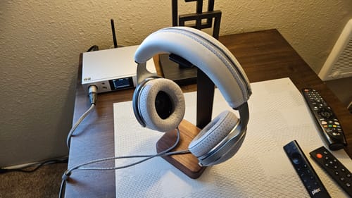 Customer's Focal Clear Headphones with a grey headband cover on a stand, connected to a DAC/AMP on a desk.