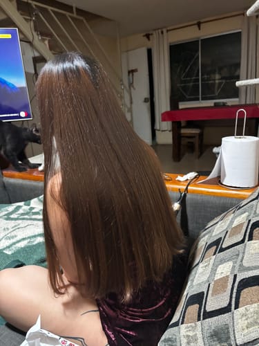 Clienta mostrando su cabello largo, liso y brillante después de usar la Mascarilla Vita Power.