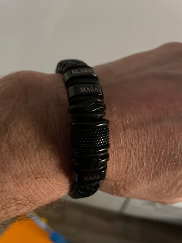 Customer wearing the black personalized bracelet on their wrist, engraved with the names Klara, Maša, and Kaja.