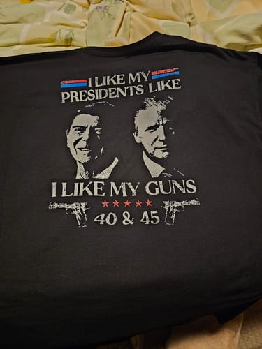 Customer's black 'I Like My Presidents Like I Like My Guns 40 and 45' t-shirt laid out flat, showing the full graphic.
