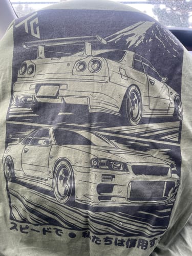 Close-up on the back of a customer's MANGA TEE, showing the large, black car graphic.