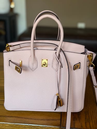 Customer's light pink LALUVA Warkin Bag with gold hardware details, sitting on a wooden surface.