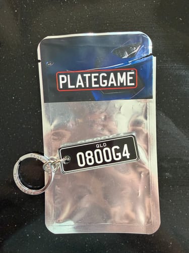 Customer's QLD Classic Licence Plate Custom Keychain inside its clear and branded product packaging.