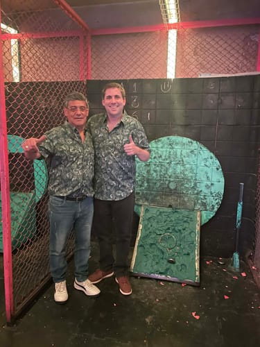 Two customers wearing matching Jurassic Park "Clever Girl" short sleeve shirts indoors.