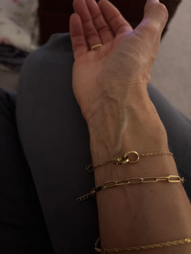 Customer's wrist wearing the gold Eternity Linked Bracelet stacked with two other similar bracelets.