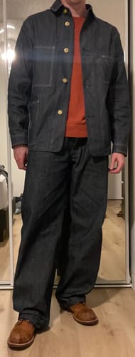 Reviewer stands wearing the Lot 811 Selvedge Denim Chore Coat unbuttoned over an orange sweater.