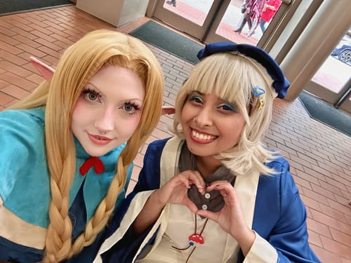 Customer in cosplay wearing H2O Olive contacts next to another person. Her eyes appear large and defined.