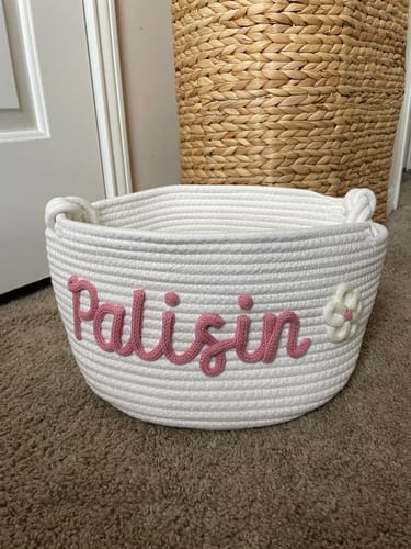 Customer's personalized white rope basket with the name 'Palisin' in pink and a flower.