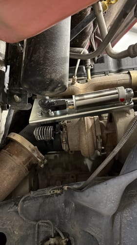 Close-up of the customer's PRXB Exhaust Brake Kit actuator installed on their Cummins engine's exhaust system.