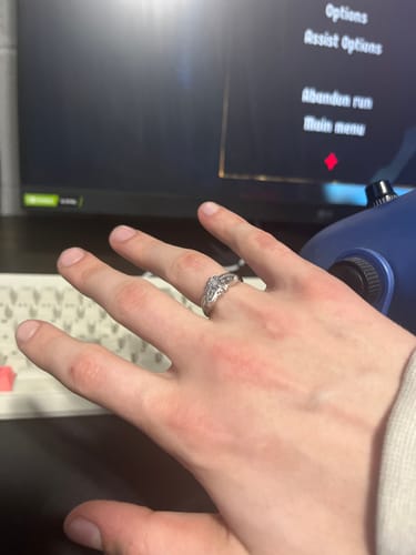 A reviewer's hand wearing the silver MOTH RING on their ring finger in front of a computer monitor and keyboard.
