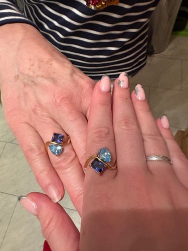 Customer and her mother showing their matching Navae Birthstone Rings with light blue and dark purple stones.