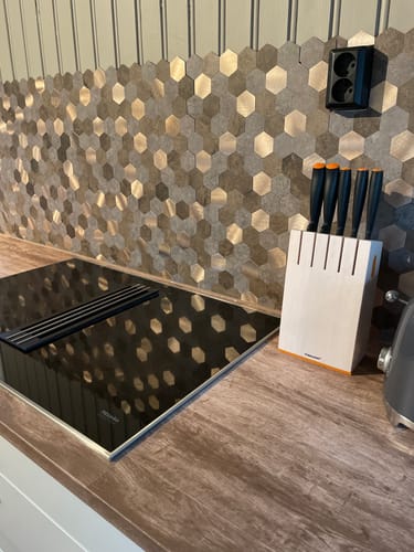 Kundens Mocca hexagon selvklebende veggfliser installert som en moderne bakvegg på et kjøkken.