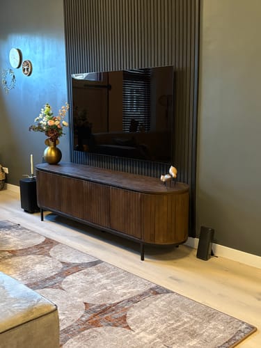 Recensents donkerbruine Tora tv-meubel van massief mangohout in een stijlvol ingerichte woonkamer.