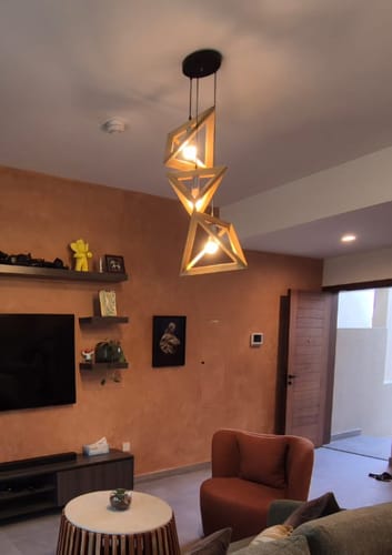 Customer's set of three geometric, wooden Space Lamps hanging together in a living room.
